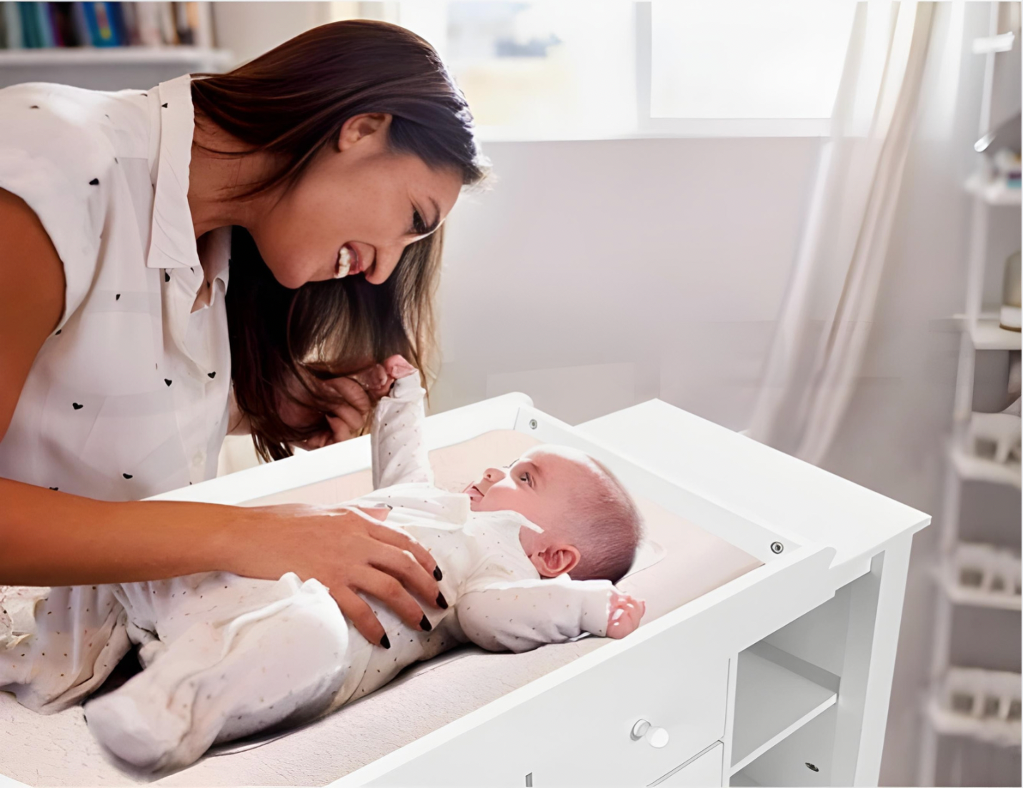 Mother changing baby on baby change table in nursery
