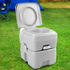 Portable camping toilet with lid closed set up outdoors